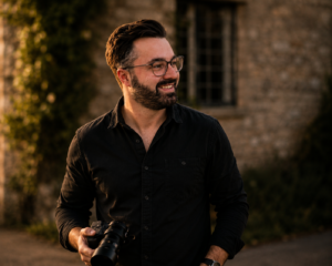 Ed Bray, Cambridge wedding videographer, holding a camera outdoors